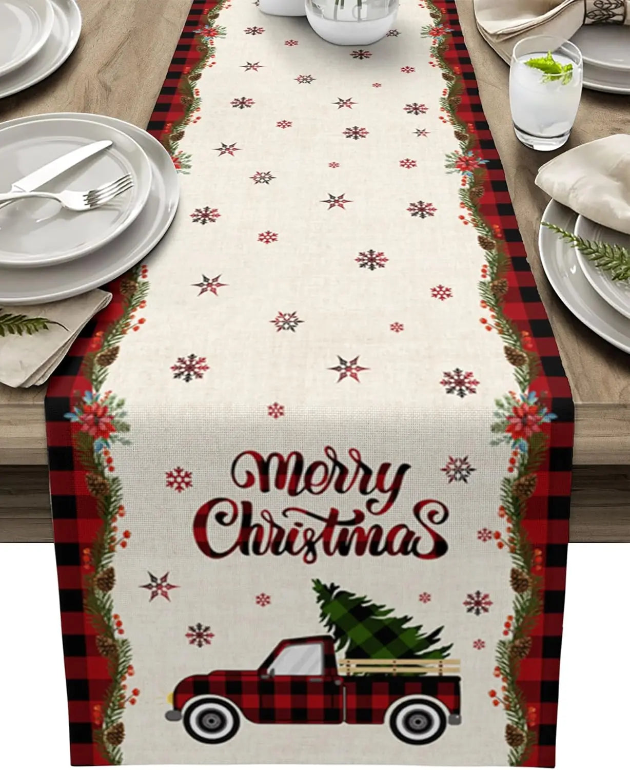 Chemin de table de Noël avec motifs de flocons de neige et d'un vieux camion rouge transportant un sapin décoré.