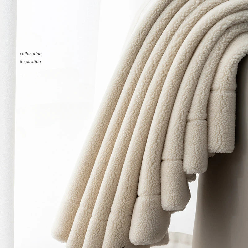 Couverture douillette beige posée sur un fauteuil élégant, ajoutant une touche de confort et de style à votre décoration intérieure. Idéale pour créer une atmosphère chaleureuse dans votre salon ou chambre.