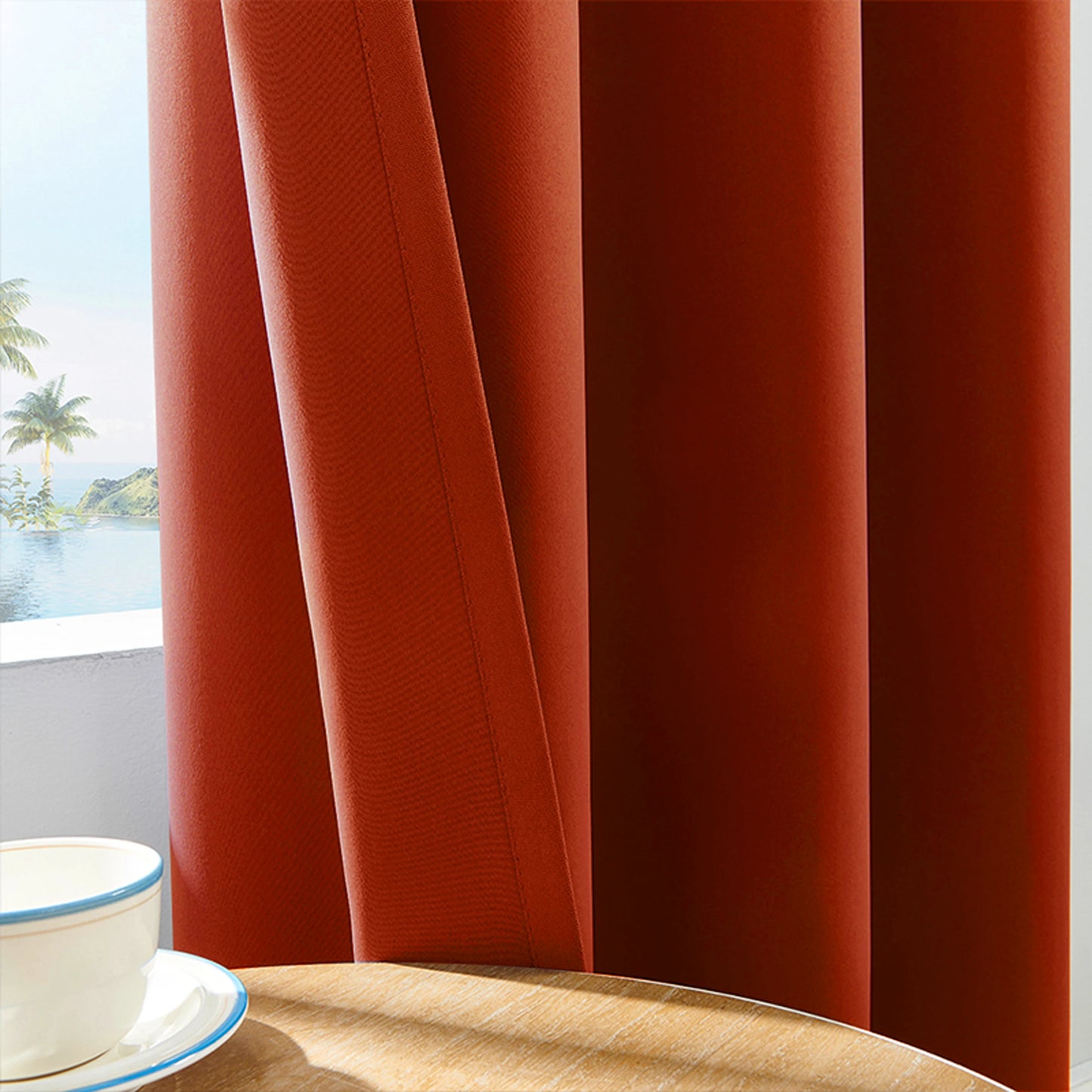 Gros plan sur un rideau drapé orange brûlé avec texture en tissu épais, partiellement ouvert, laissant entrevoir un paysage tropical à l'extérieur.