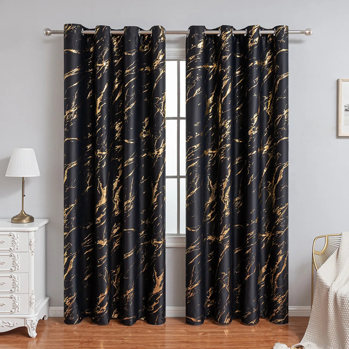 Rideaux occultants noirs élégants avec un motif marbré doré, suspendus à une tringle argentée, dans une pièce lumineuse à la décoration classique.