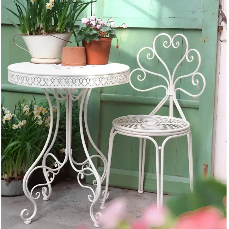 table extérieure ronde métal ajouré vintage chaises motifs floraux patio jardin