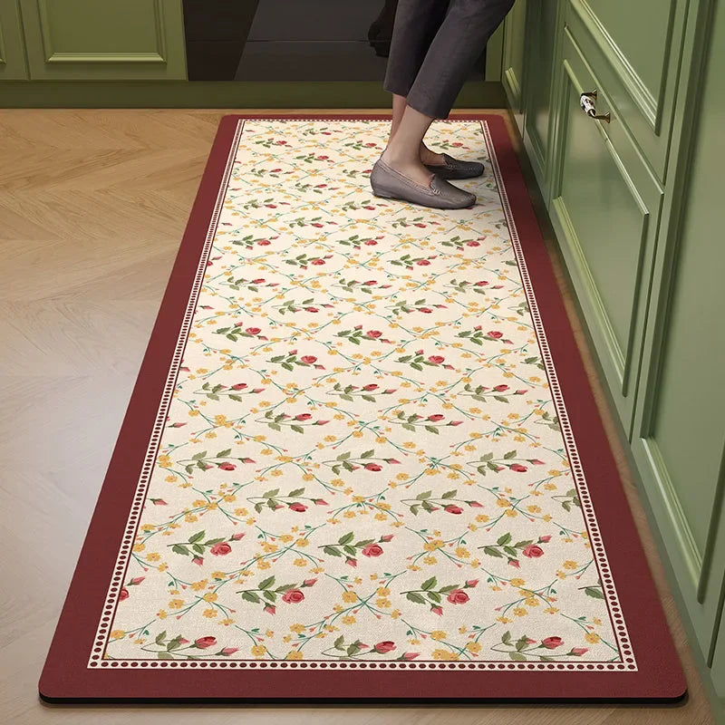 Tapis de cuisine motif floral avec des roses et des feuilles vertes sur un fond crème, encadré d'une bordure rouge.