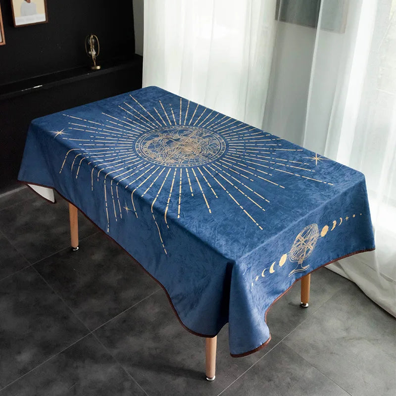 Une nappe décorative de table bleu foncé ornée de motifs dorés représentant le soleil et les phases de la lune.