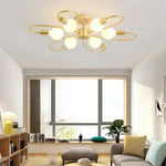 plafonnier moderne or noir ampoules led structure circulaire branches incurvées opalescent surface fixations