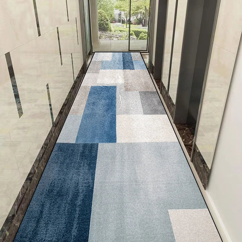 Couloir avec motif géométrique de carreaux de moquette bleus et gris.