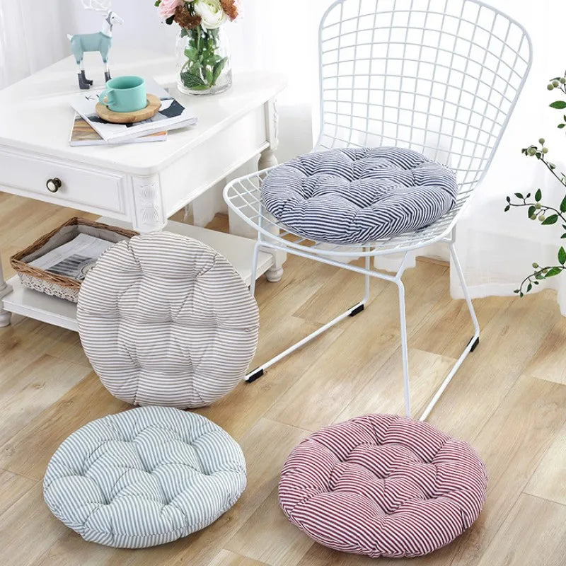 Coussin rond à rayures bourgogne sur un banc de jardin