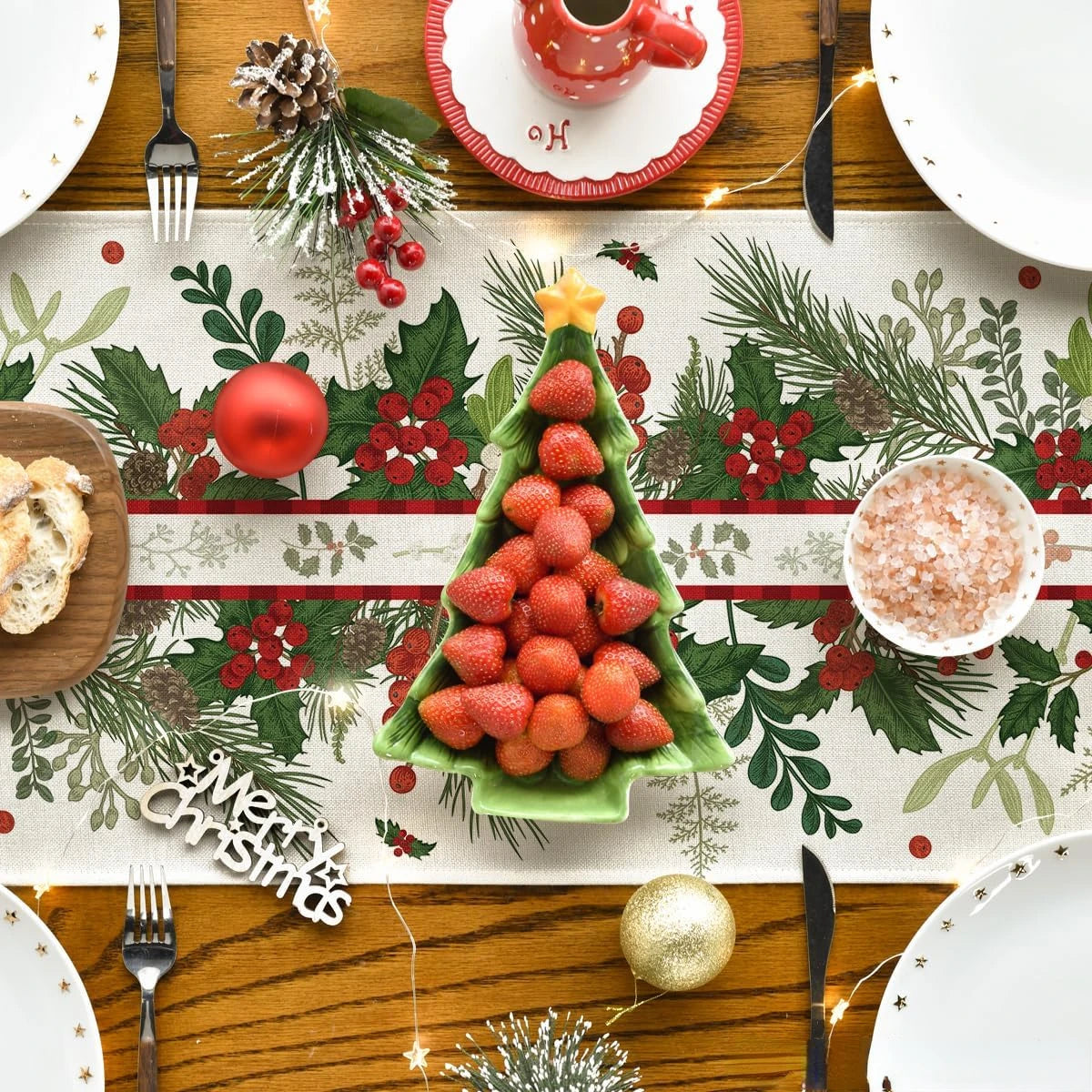 Une assiette festive décorée de fruits rouges, de verdure et d'éléments décoratifs de Noël, créant une ambiance chaleureuse et conviviale pour une célébration de la saison.