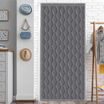 Rideau de porte thermique gris à motif nid d’abeille dans un couloir d’entrée lumineux avec décor mural.