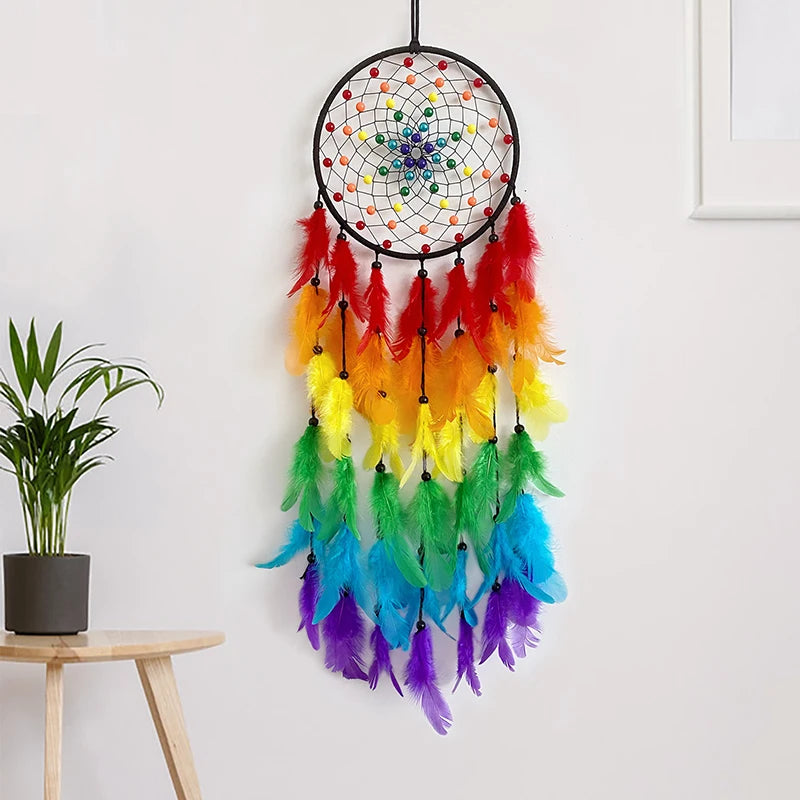 Un capteur de rêves coloré et ornementé suspendu au mur, avec des plumes multicolores disposées de manière décorative.