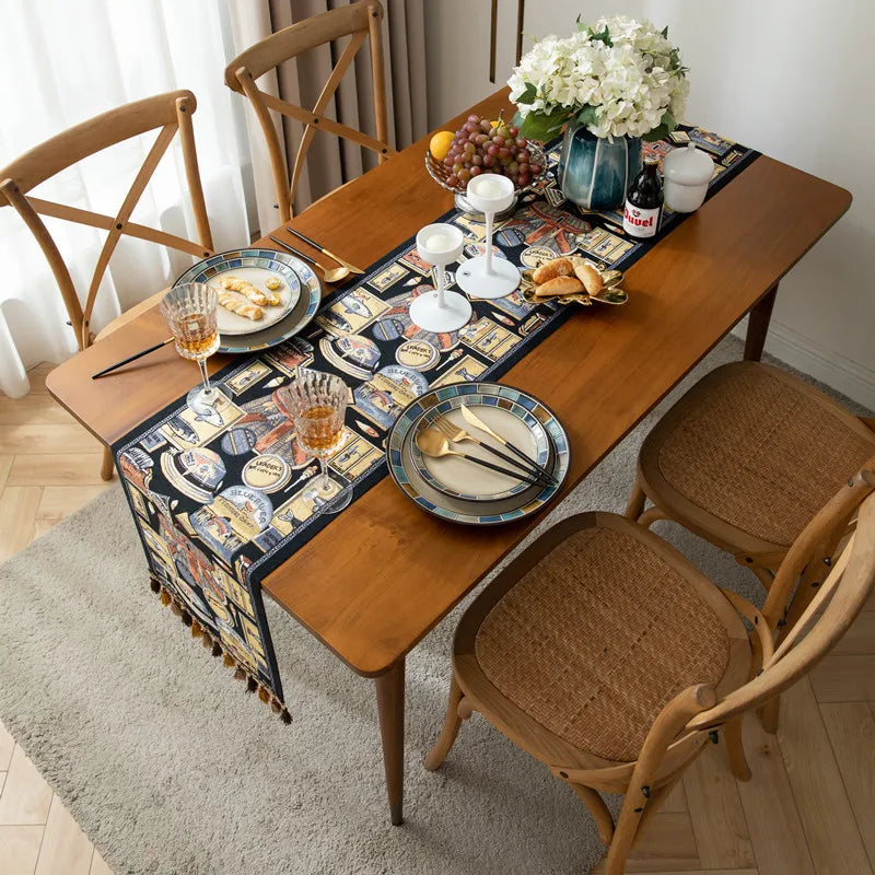 Une table en bois avec une nappe rayée, remplie de plats et de verres, ainsi que des fleurs, créant une scène conviviale et chaleureuse.