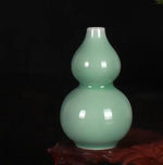 Vase en forme de gourde en verre opaque de couleur vert pastel.
