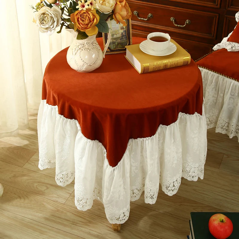 Une table couverte d'une nappe rouge et blanche ornée de fleurs et accessoires décoratifs, avec une tasse de thé et des livres posés dessus, créant une ambiance chaleureuse et accueillante.
