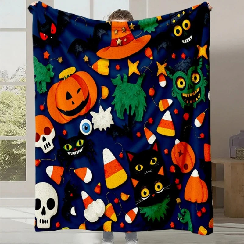 Couverture festive avec des motifs d'Halloween, notamment des citrouilles, des bonbons, des chats noirs et des éléments décoratifs saisonniers.