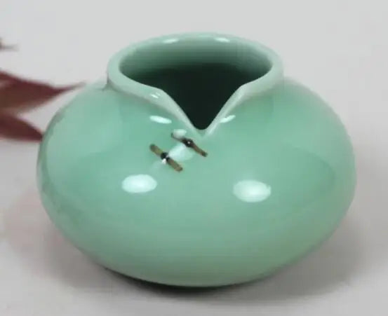 Vase de céramique de couleur vert menthe avec deux petits anneaux sur le côté.