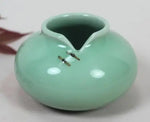 Vase de céramique de couleur vert menthe avec deux petits anneaux sur le côté.