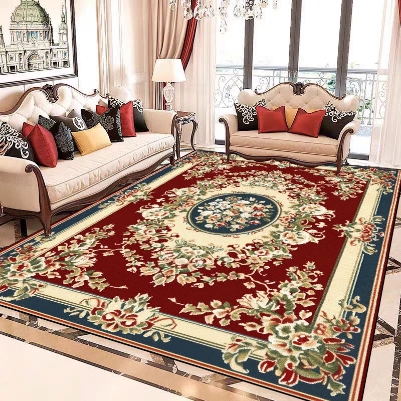 Luxueuse salle de séjour meublée avec un canapé et des fauteuils ornés de riches motifs floraux sur un tapis rouge de style oriental.