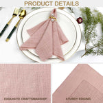 Nappes en lin rose pâle avec finition robuste, décorées de perles, sur une assiette blanche avec des couverts dorés et des éléments décoratifs botaniques.