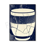 Un bol en céramique blanc et bleu foncé, avec des motifs géométriques et des fissures intéressantes sur la surface, créant une texture et un style unique.