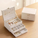 boîte rangement bijoux cuir blanc moderne élégante poignées métalliques verrouillable intérieure motifs géométriques