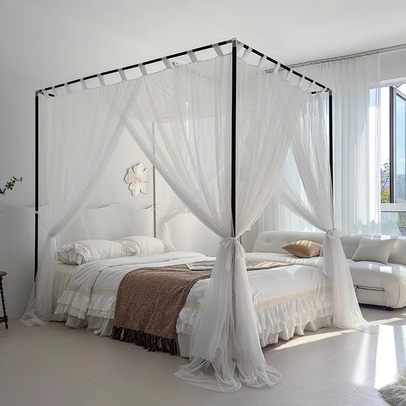 Chambre à coucher élégante avec un grand lit à baldaquin blanc, des draps blancs et des rideaux transparents pour un style apaisant et raffiné.
