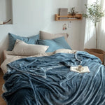 Une chambre confortable et accueillante, avec un lit douillet et des oreillers moelleux, dans des tons de bleu et de beige, créant une atmosphère sereine et reposante.