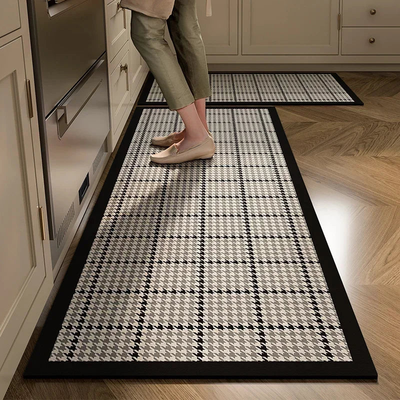 Un tapis moderne et géométrique dans une cuisine avec une structure de carreaux noir et blanc, contrastant avec le sol en bois.