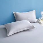 Des oreillers blancs moelleux sur un fond bleu clair, créant une ambiance de détente et de confort.