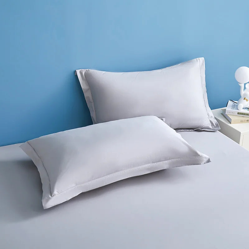 Des oreillers blancs moelleux sur un fond bleu clair, créant une ambiance de détente et de confort.