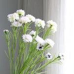 décoration intérieure bouquet fleurs artificielles bleues blanches roses longues tiges vertes vase transparent festonnée