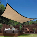 Voile d'ombrage jaune tendue sur terrasse avec mobilier de jardin