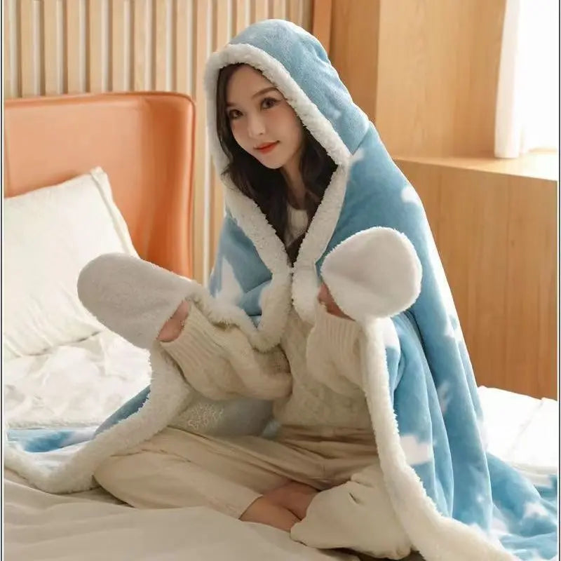 Le portrait montre une femme avec un manteau en polaire bleu clair, assise sur un lit et enveloppée dans une couverture beige, donnant une impression de confort et de détente.