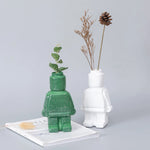 vase moderne figurine lego noir blanc vert fleurs eucalyptus branches cônes pins ludique décoration