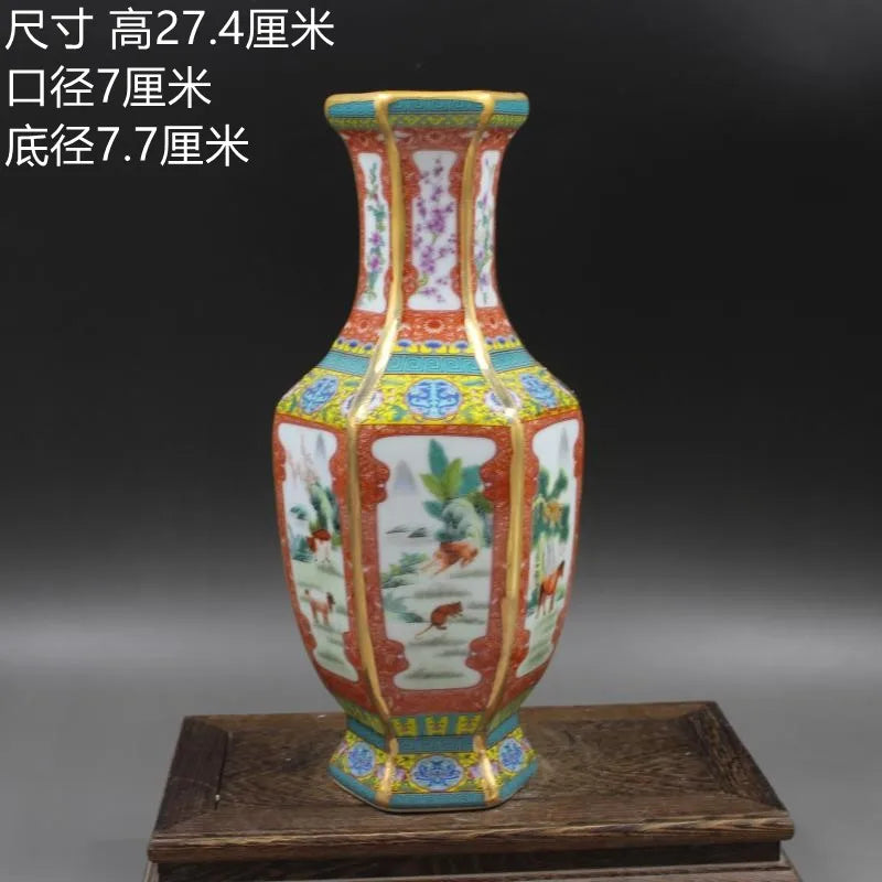 Vase de porcelaine décoré de motifs floraux et paysagers dans des tons rouge, bleu et vert, sur un support en bois.