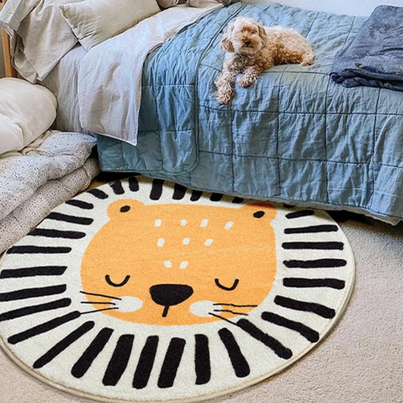 Un tapis rond représentant une figure de tigre avec un motif en rayures noires et blanches, sur un lit recouvert d'une couette en nuances de bleu.
