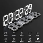 Horloge digitale blanche accrochée au mur avec télécommande à côté