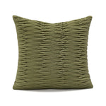 Coussin décoratif vert olive orné de motifs plissés élégants, créant une texture intéressante et une touche de sophistication.