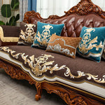 Canapé de luxe en bois sculpté avec des coussins décoratifs bleus et dorés, reflétant un style baroque élégant et sophistiqué.