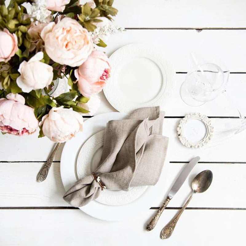 Une table élégante avec de jolies fleurs, des couverts et une décoration chic.