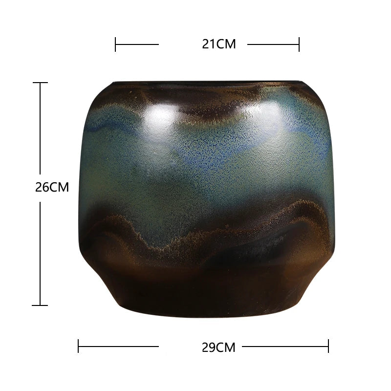 Un élégant vase de style moderne avec des nuances de vert, de brun et de bleu, aux formes arrondies et lisse.