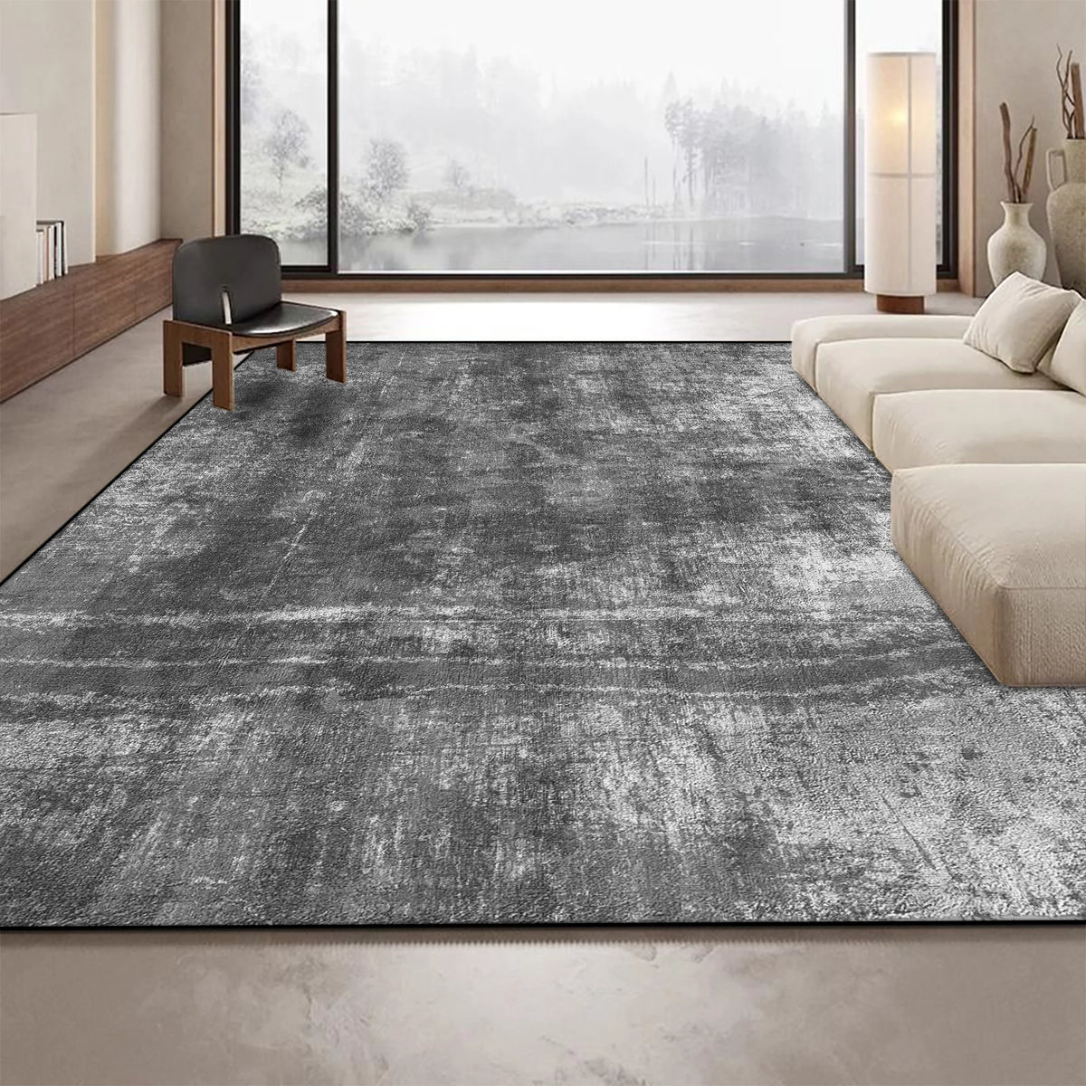 Un tapis gris moderne et élégant dans un intérieur épuré, avec de grandes fenêtres offrant une vue sur un paysage enneigé.