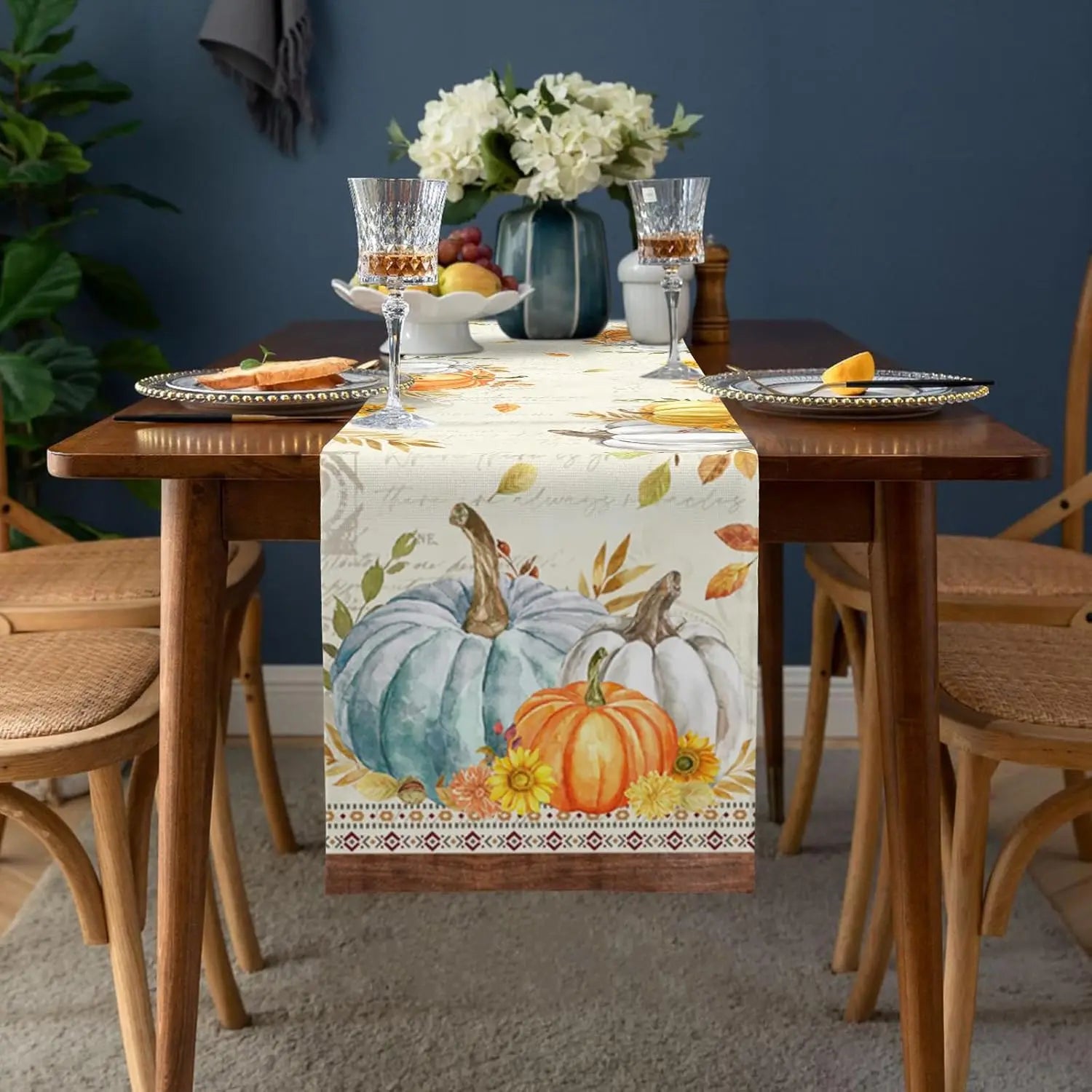 Une élégante décoration de table automnale avec des citrouilles, des fleurs et des accessoires décoratifs dans des tons chauds.