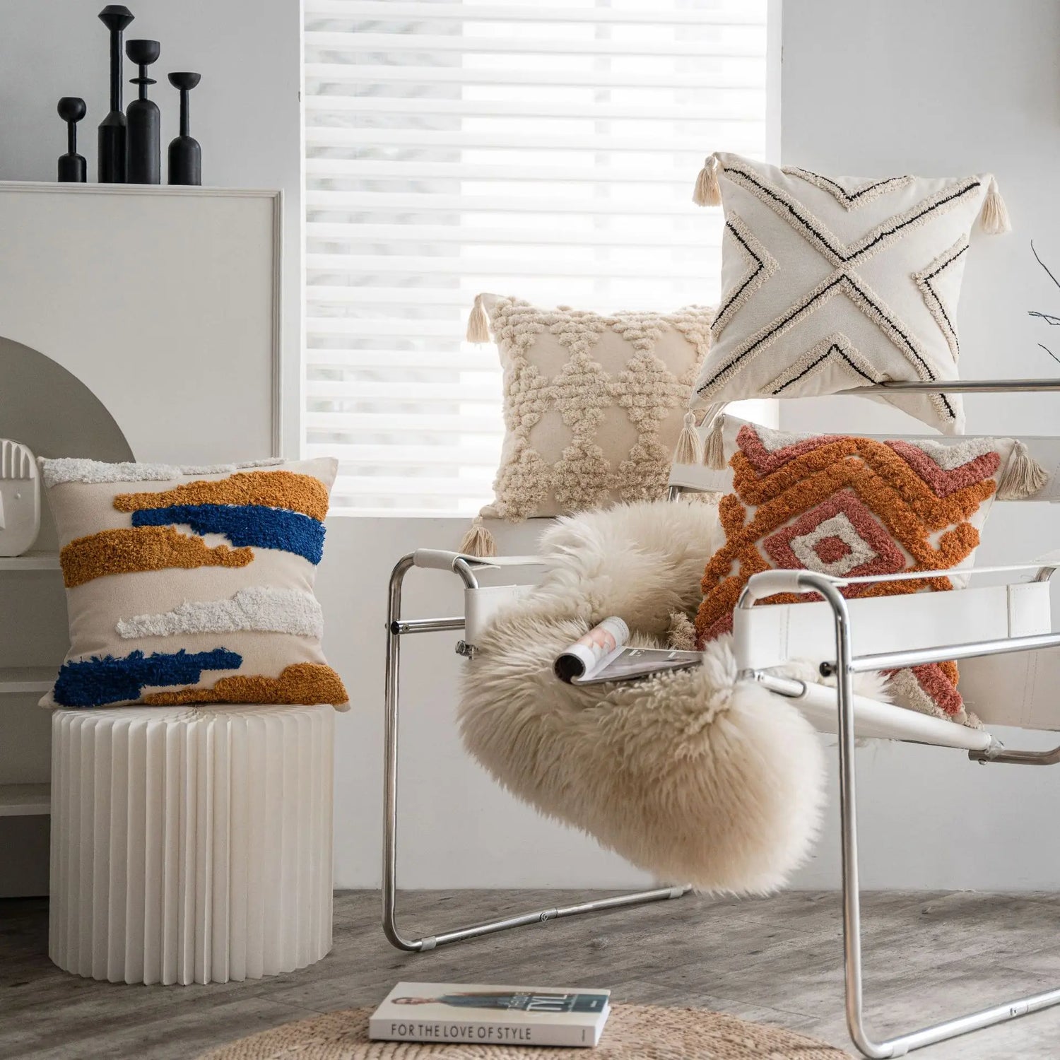 Cette image décorative présente un arrangement de coussins et d'accessoires dans des tons neutres et chauds, créant une ambiance apaisante et élégante dans cet espace de vie.
