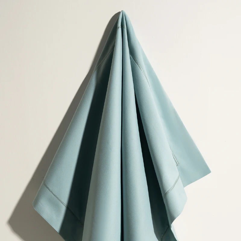 Une serviette élégante et raffinée en nuances de bleu pâle, aux plis harmonieux et à l'apparence soignée.