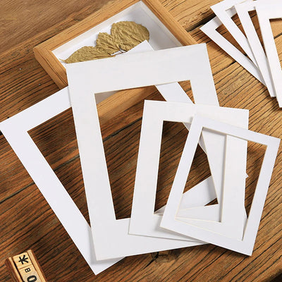 Cadre photo en carton blanc moderne posé sur une table