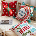 Un ensemble de coussins décoratifs colorés et amusants, avec des motifs à pois rouges et blancs ainsi que des motifs graphiques vivaces, créant une ambiance ludique et chaleureuse dans la pièce.