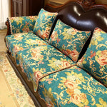 Un canapé vintage en cuir brun orné de coussins aux motifs floraux colorés, créant une atmosphère chaleureuse et élégante dans cette pièce.