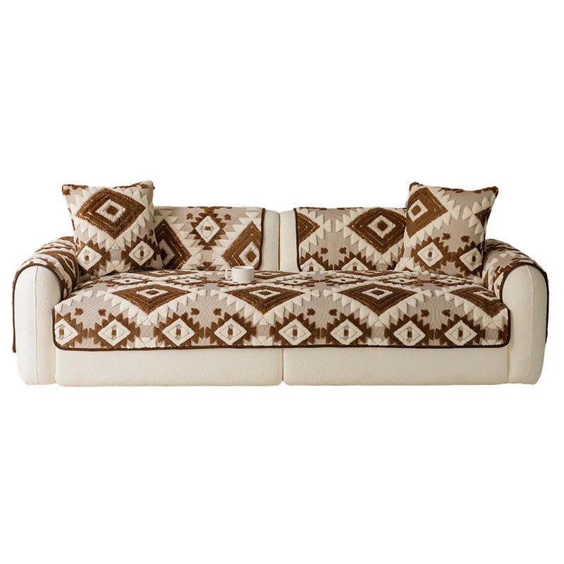 Canapé de style bohème avec motifs géométriques en couleurs terre cuite sur fond crème.