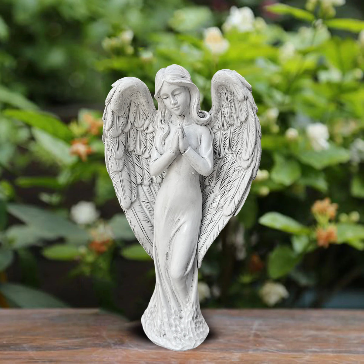Statue d'ange placée dans un jardin avec plantes