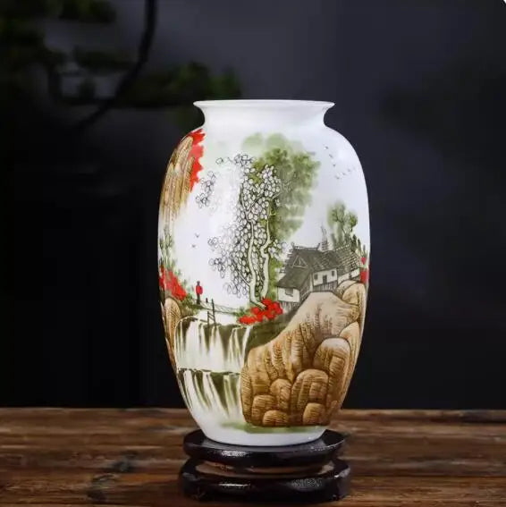 Un vase décoratif avec une scène pittoresque rurale représentant une maison, une cascade et des collines verdoyantes.