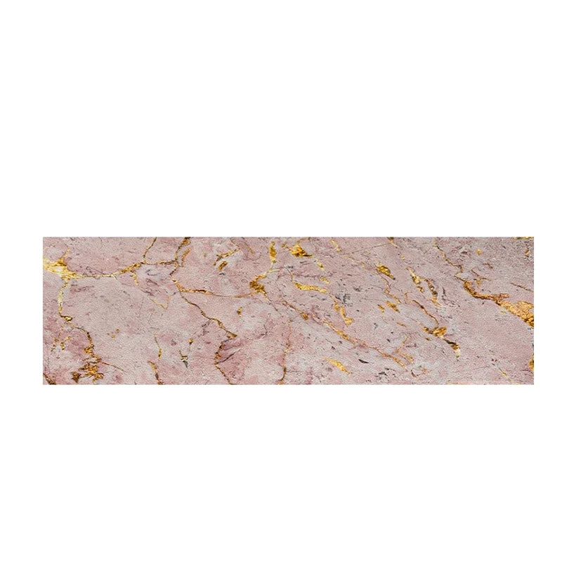 Cette image montre une texture de surface de pierre rose parsemée de veines dorées, créant un motif décoratif et élégant.